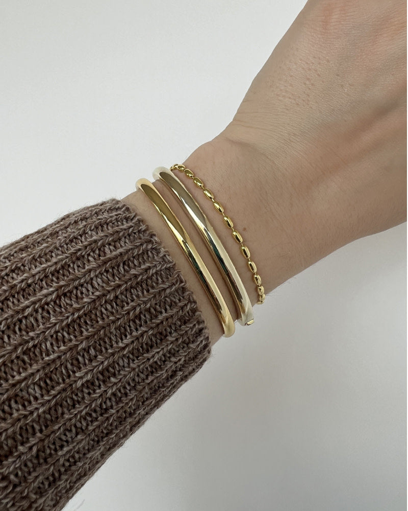 This classic bangle bracelet can seamlessly integrate into any look. Perfect to wear alone or layer with other bracelets, this gold bangle is a chic must-have