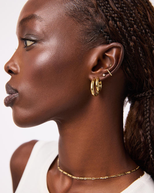 Totally timeless, these gold hoop earrings are plated in 14k gold and feature a chunky silhouette that’s perfect for styling solo or adding to any stack.