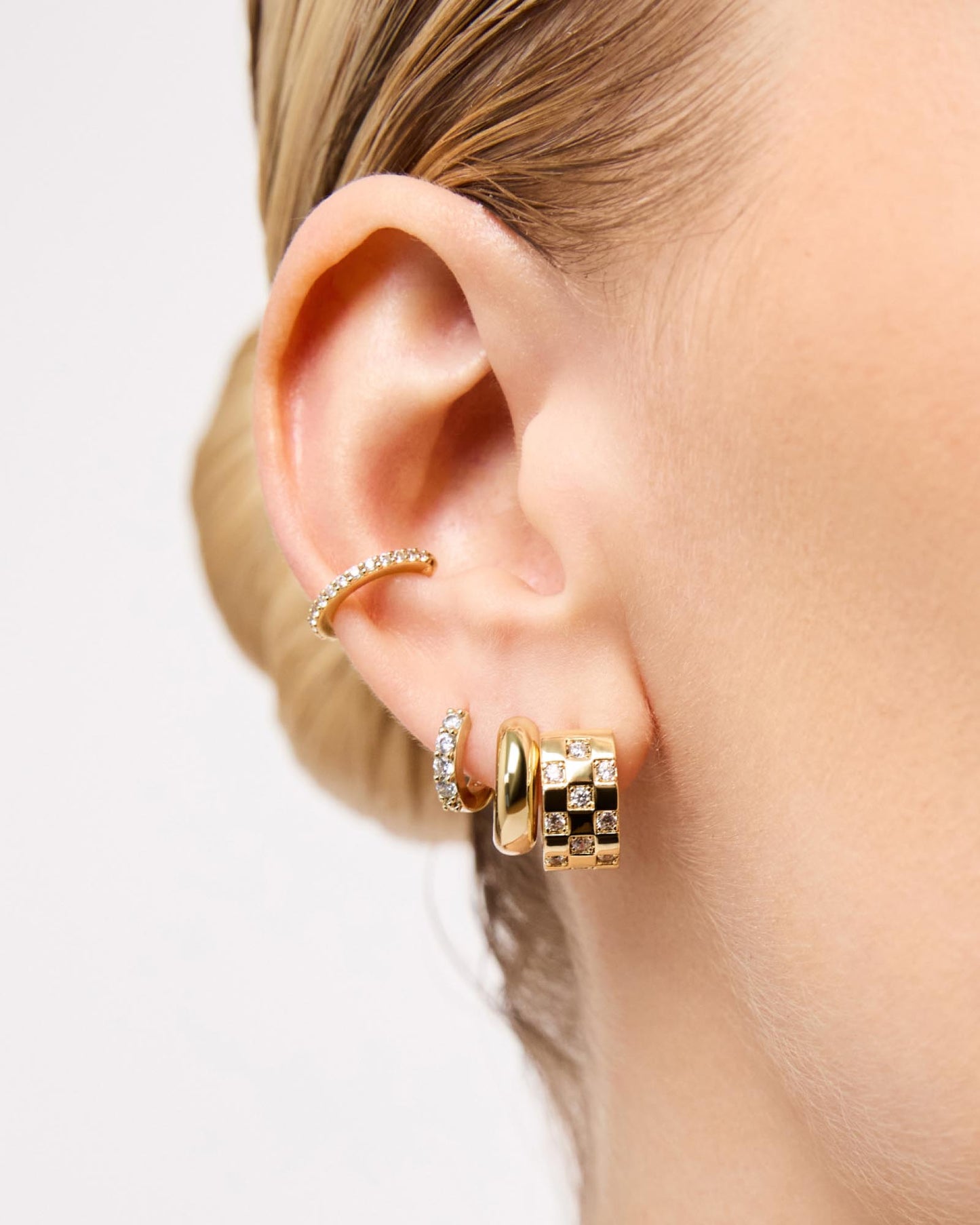 Be the first to try on these stylish gold huggie hoop earrings made of sustainable Sterling Silver and covered with sparkling gemstones in a sleek pavé setting.