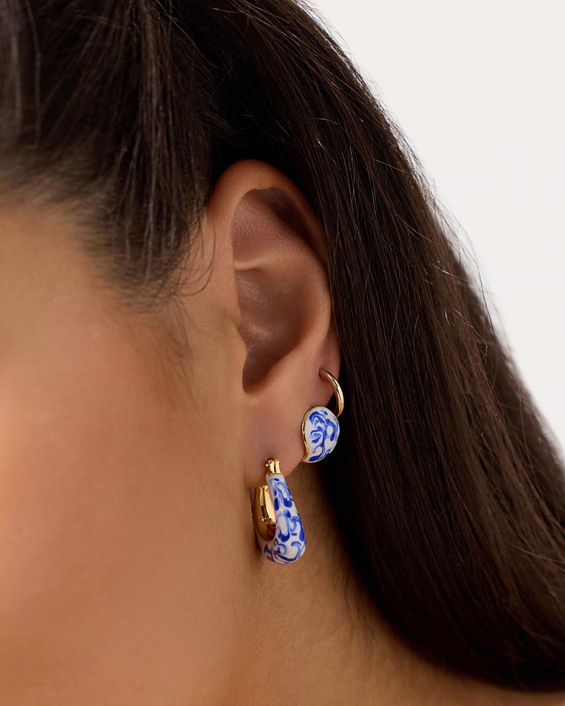 Simple yet unique, these statement earrings plated in 14k gold feature a spherical design and handcrafted marble blue design made to elevate every stack.